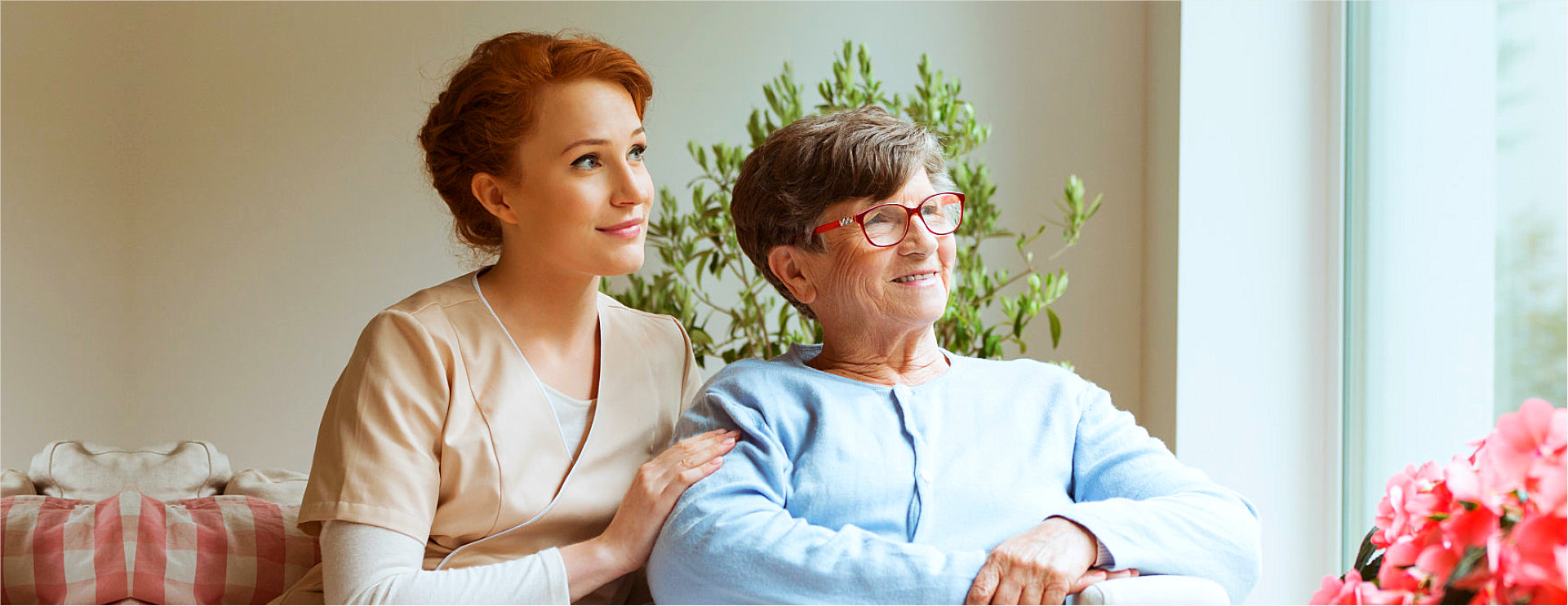 caregiver and senior woman looking at the window